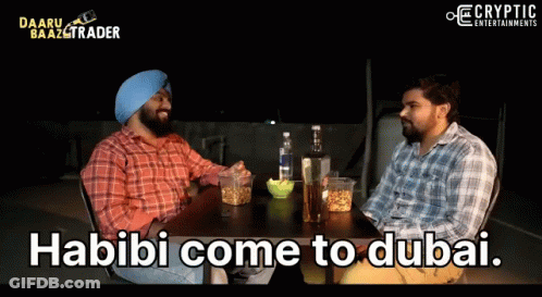 Two Men Are Sitting At A Table With The Words Habibi Come To Dubai On The Screen GIF