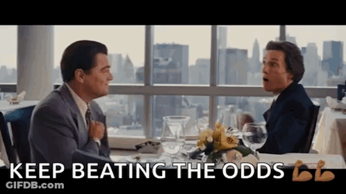 Two Men Are Sitting At A Table With The Words " Keep Beating The Odds " On The Bottom GIF