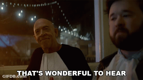 Two Men Are Sitting At A Table With The Words That 'S Wonderful To Hear GIF