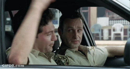 Two Men Are Sitting In A Car And One Has A Sheriff 'S Badge On His Shirt GIF