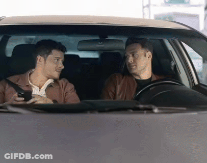 Two Men Are Sitting In A Car And One Is Holding A Cell Phone GIF