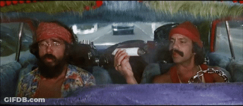 Two Men Are Sitting In A Car And One Is Holding A Cigarette GIF