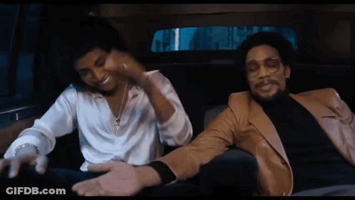 Two Men Are Sitting In A Car And One Is Wearing Glasses GIF