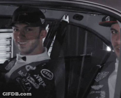 Two Men Are Sitting In A Car With One Wearing A Hat That Says Esso On It GIF