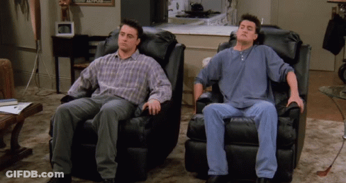 Two Men Are Sitting In Black Leather Chairs With Their Heads Down GIF