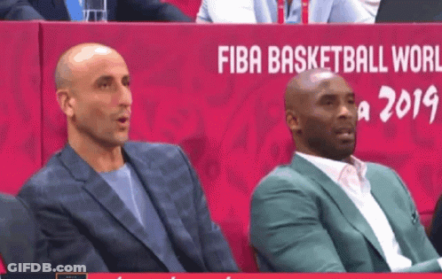 Two Men Are Sitting In Front Of A Sign That Says Fiba Basketball World GIF