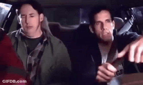 Two Men Are Sitting In The Back Seat Of A Car And One Of Them Is Pointing At The Camera . GIF