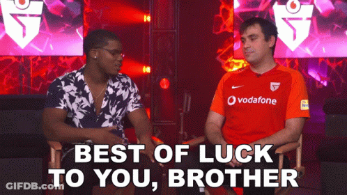 Two Men Are Sitting Next To Each Other And One Is Wearing A Red Vodafone Shirt GIF