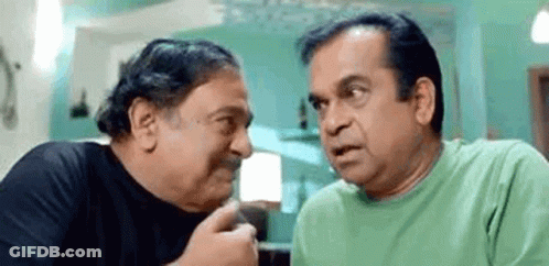 Two Men Are Sitting Next To Each Other And Talking To Each Other . One Of The Men Is Wearing A Green Shirt . GIF