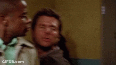 Two Men Are Sitting Next To Each Other In A Room . One Of The Men Is Kissing The Other On The Cheek . GIF