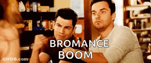 Two Men Are Sitting Next To Each Other In A Room With The Words `` Bromance Boom '' Written On The Bottom . GIF