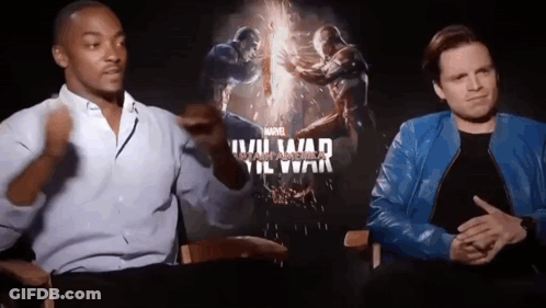 Two Men Are Sitting Next To Each Other In Front Of A Movie Poster For A Movie . GIF