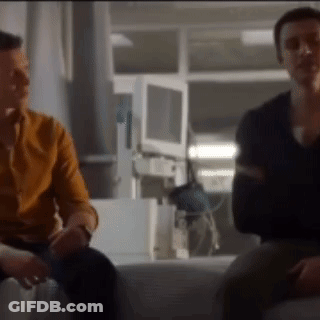 Two Men Are Sitting Next To Each Other On A Bed In A Hospital Room . GIF