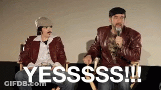 Two Men Are Sitting Next To Each Other On A Couch And One Of Them Is Holding A Microphone And Saying Yesssss ! GIF