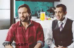 Two Men Are Sitting Next To Each Other On A Couch . GIF