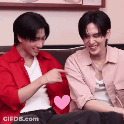 Two Men Are Sitting Next To Each Other With One Pointing At The Other GIF