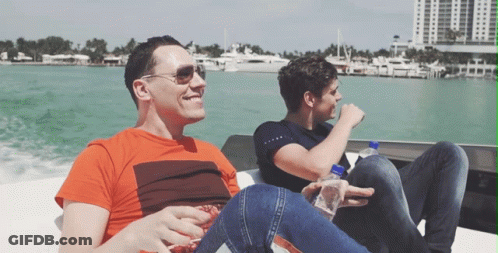 Two Men Are Sitting On A Boat In The Water And One Has A Bottle Of Aquafina Water In His Hand GIF