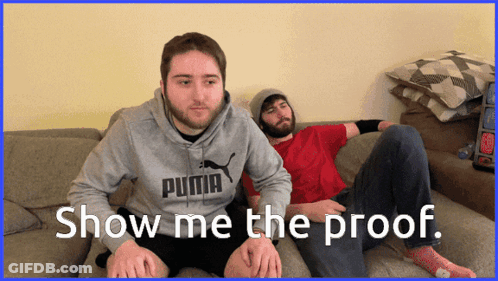 Two Men Are Sitting On A Couch And One Has A Puma Sweatshirt On GIF