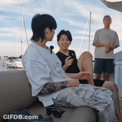 Two Men Are Sitting On A Couch And One Has A Tattoo On His Arm That Says ' I Love You ' GIF