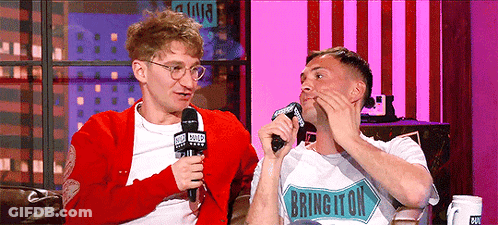 Two Men Are Sitting On A Couch And One Of Them Has A Shirt That Says Brington GIF