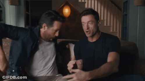 Two Men Are Sitting On A Couch And One Of Them Is Wearing A Blue Shirt GIF
