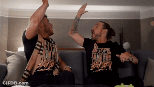 Two Men Are Sitting On A Couch And One Of Them Is Wearing A Shirt That Says ' Dirty Boy ' GIF