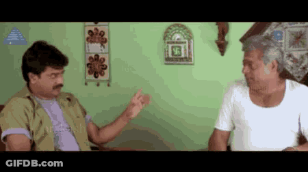 Two Men Are Sitting On A Couch And Talking To Each Other . GIF