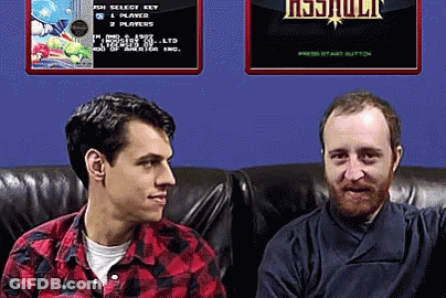 Two Men Are Sitting On A Couch In Front Of A Screen That Says ' Resjuult ' On It GIF