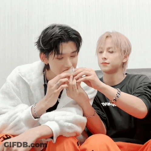 Two Men Are Sitting On A Couch One Wearing A Black Shirt That Says Tmn GIF