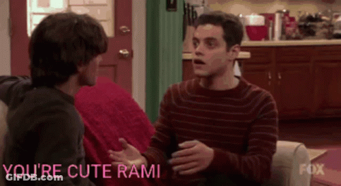 Two Men Are Sitting On A Couch With The Words You 'Re Cute Rami Written On The Bottom GIF