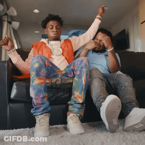 Two Men Are Sitting On A Couch With Their Arms Up GIF