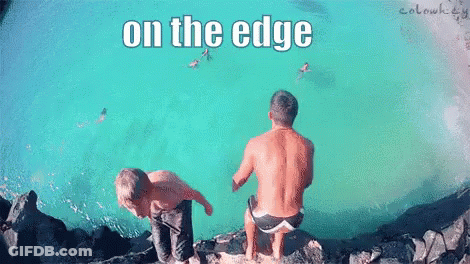 Two Men Are Sitting On The Edge Of A Body Of Water With The Words On The Edge Above Them GIF