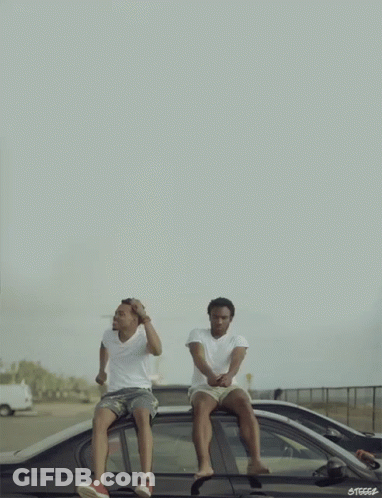 Two Men Are Sitting On The Roof Of A Car With The Letters Steccs On The Bottom Right GIF
