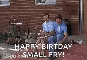 Two Men Are Sitting On The Steps Of A House Eating Food And Smoking Cigarettes . GIF