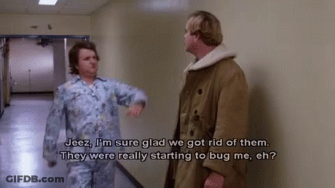 Two Men Are Standing In A Hallway Talking To Each Other And One Of Them Is Wearing Pajamas . GIF