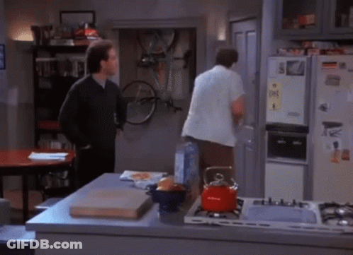 Two Men Are Standing In A Kitchen In Front Of A Refrigerator That Has A Sticker On It That Says ' S. ' GIF