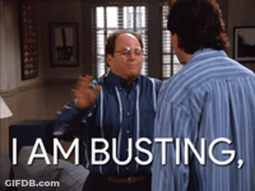 Two Men Are Standing In A Living Room With The Words I Am Busting GIF