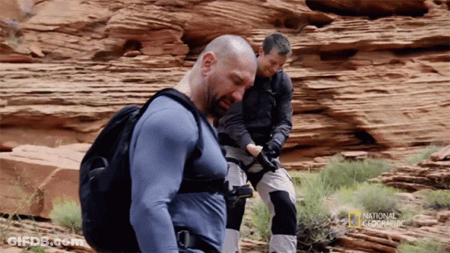Two Men Are Standing In A Rocky Area With National Geographic Written On The Bottom Right GIF