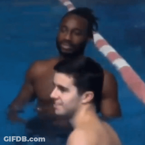 Two Men Are Standing In A Swimming Pool And One Of Them Is Looking At The Camera . GIF