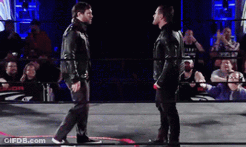 Two Men Are Standing In A Wrestling Ring With A Crowd Behind Them And A Sign That Says J.or. GIF