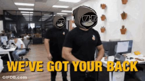 Two Men Are Standing In An Office With The Words We 'Ve Got Your Back On The Bottom GIF
