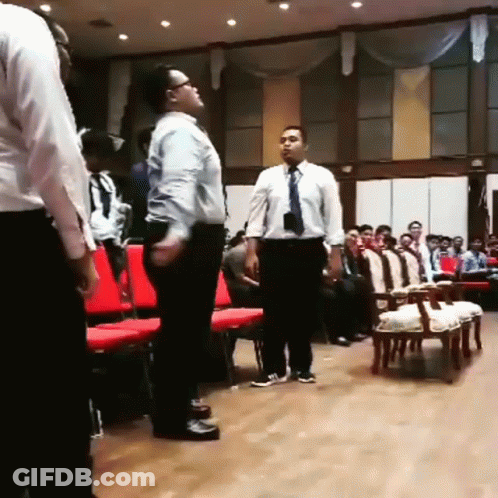 Two Men Are Standing In Front Of A Crowd Of People GIF