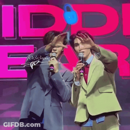 Two Men Are Standing In Front Of A Pink Sign That Says Id Ear GIF