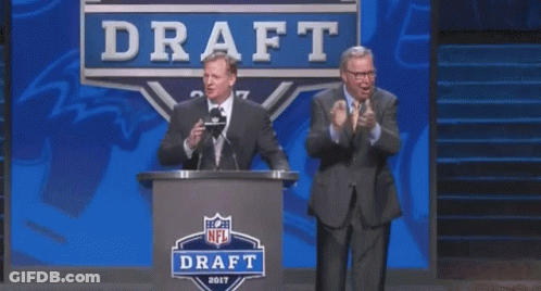 Two Men Are Standing In Front Of A Podium That Says Draft GIF