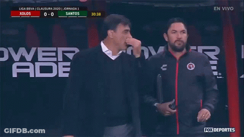 Two Men Are Standing In Front Of A Powerade Ad GIF