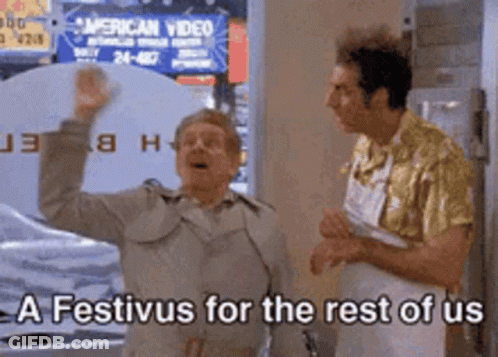 Two Men Are Standing In Front Of A Sign That Says A Festivus For The Rest Of Us . GIF