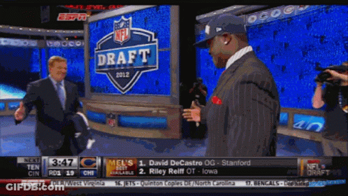 Two Men Are Standing In Front Of A Sign That Says Draft GIF