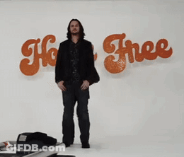 Two Men Are Standing In Front Of A Sign That Says " Ho Free " GIF