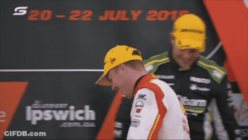 Two Men Are Standing In Front Of A Sign That Says Ipswich On It GIF