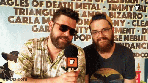 Two Men Standing In Front Of Triangle Sign GIF